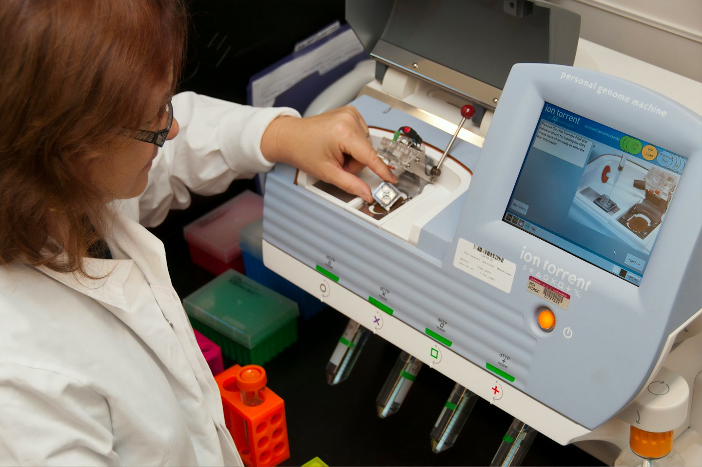 Scientist places component into personal genome machine.
